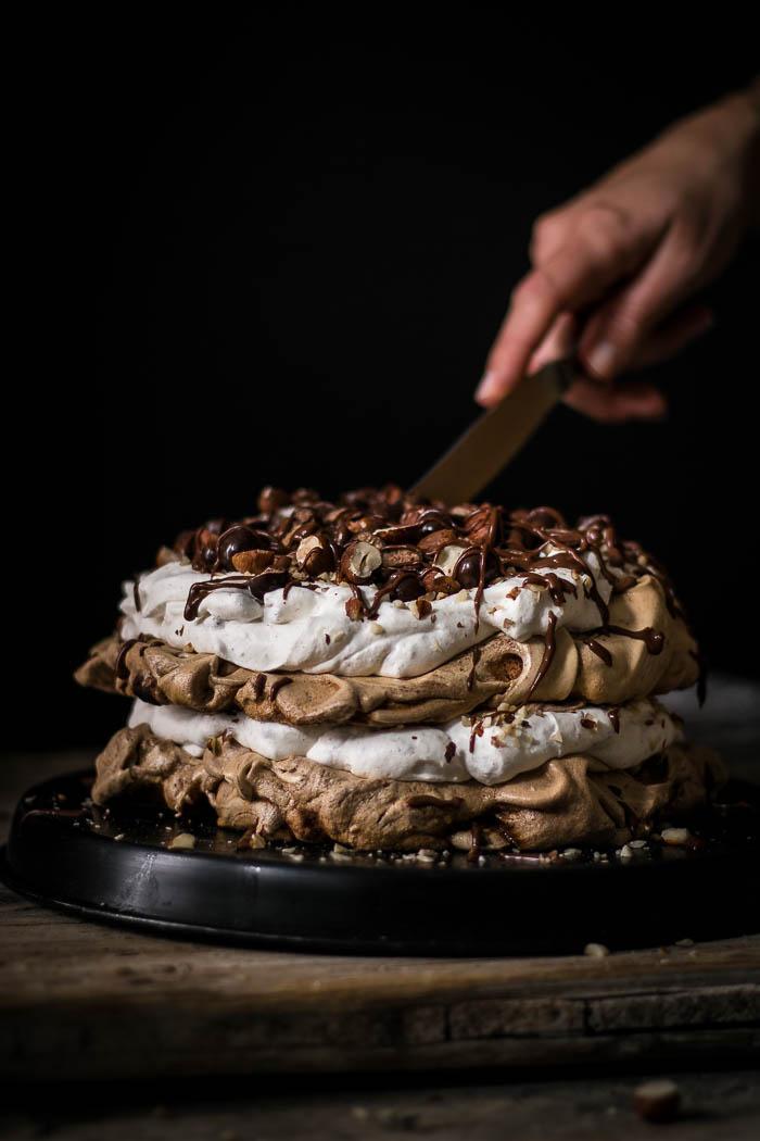Beautiful layers of crispy and chewy meringue, decadent chocolate ganache and fluffy hazelnut whipped cream are what make this delicious chocolate hazelnut pavlova cake worth celebrating this blog's first birthday.