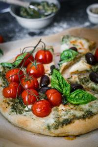 Italian flavors with a twist in one delicious spicy goat cheese pesto pizza loaded with fresh cherry tomatoes, mozarella and black olives. I could eat this pizza every day!